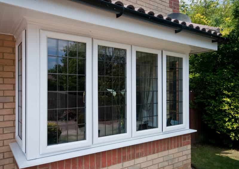 White bay window with leaded glazing beneath a tiled roof